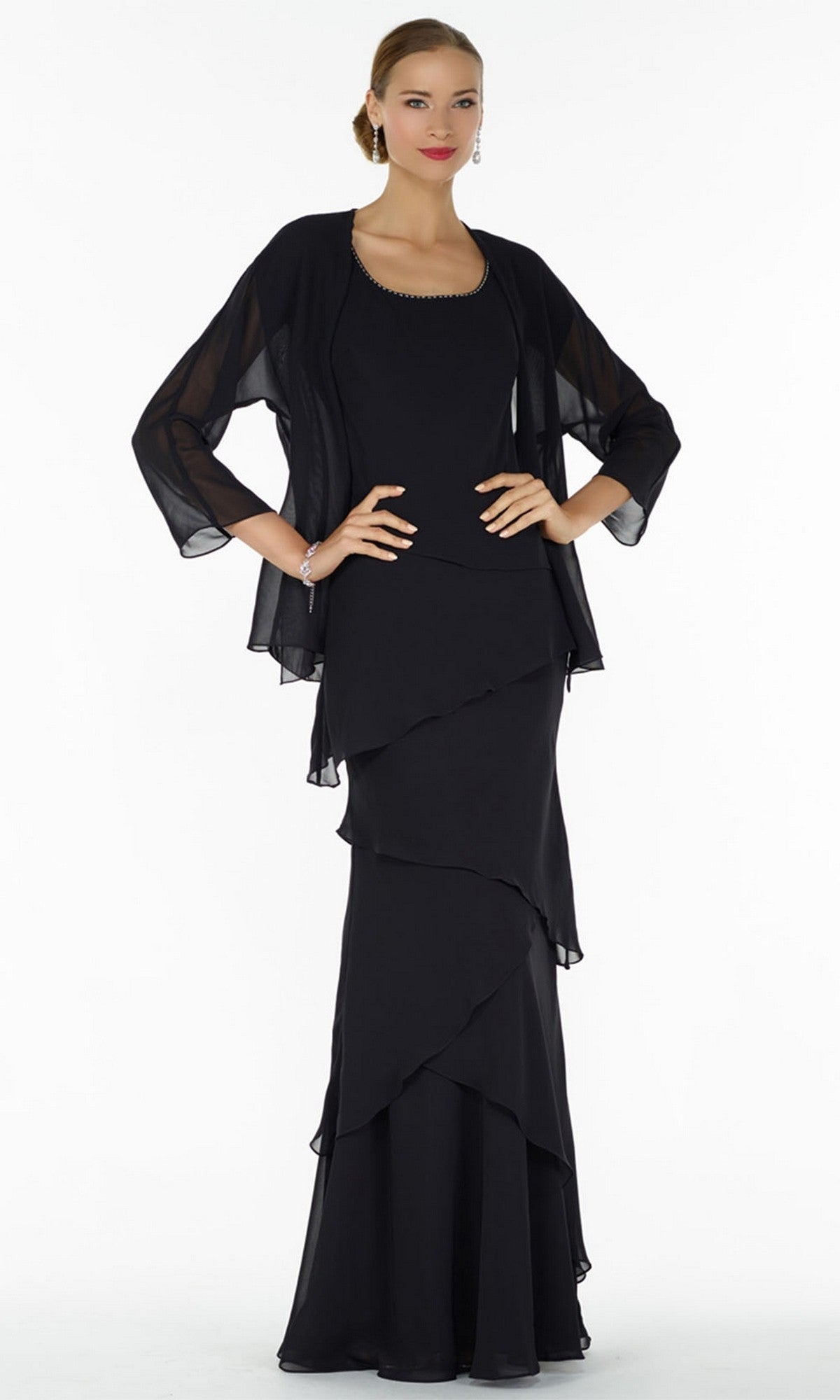 A woman in a black Alyce 29292 long formal dress with a sheer black shawl, standing against a plain white background.